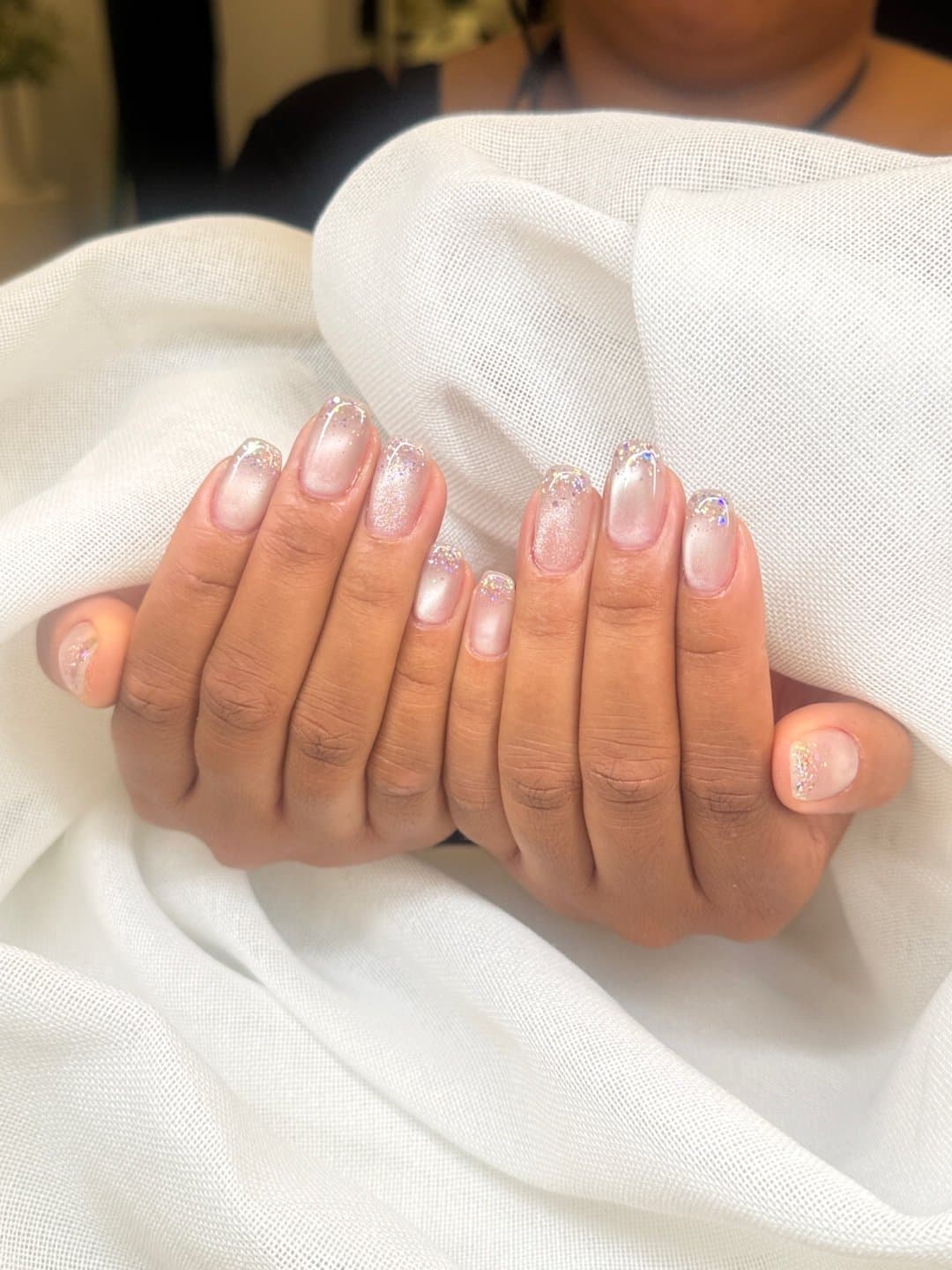 Glitter tipped gel manicure with a pearl finish